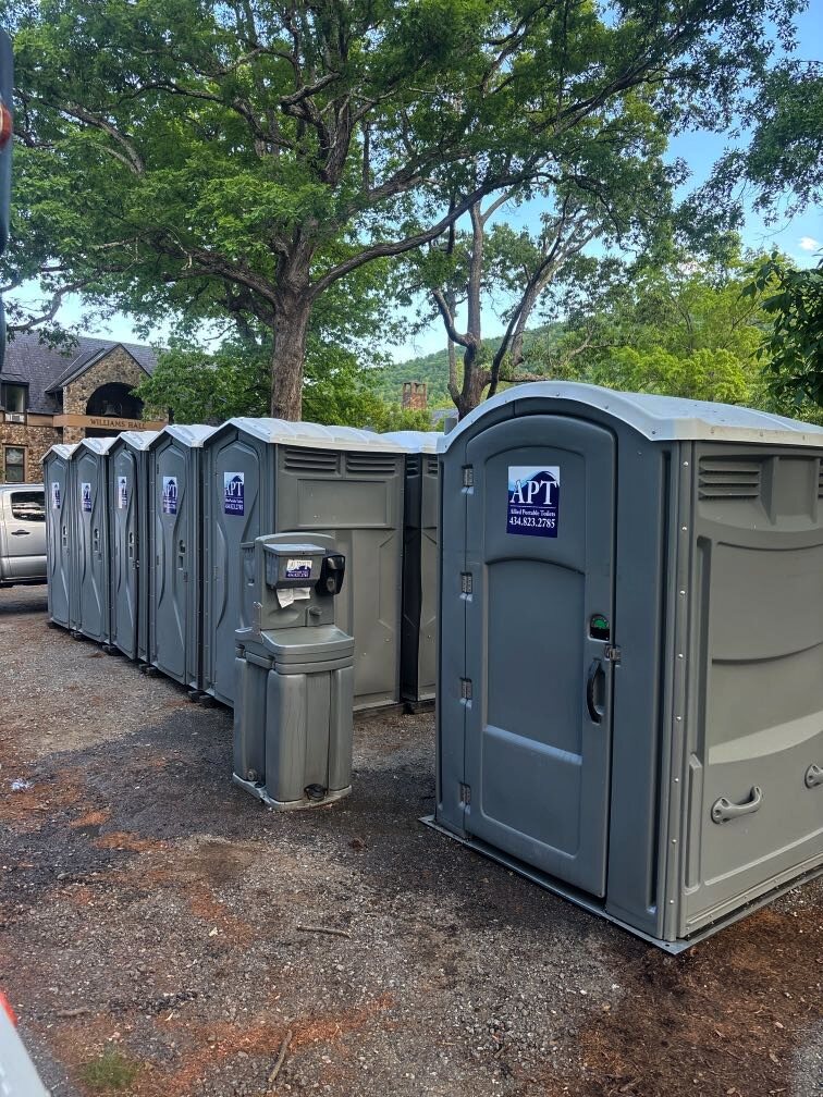 Grey APT event toilets and a portable handwashing station ready for guests